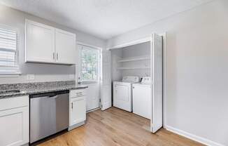 A kitchen with white cabinets and appliances.