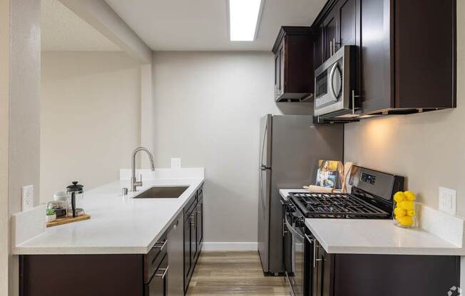 A kitchen with a white counter top and black appliances.