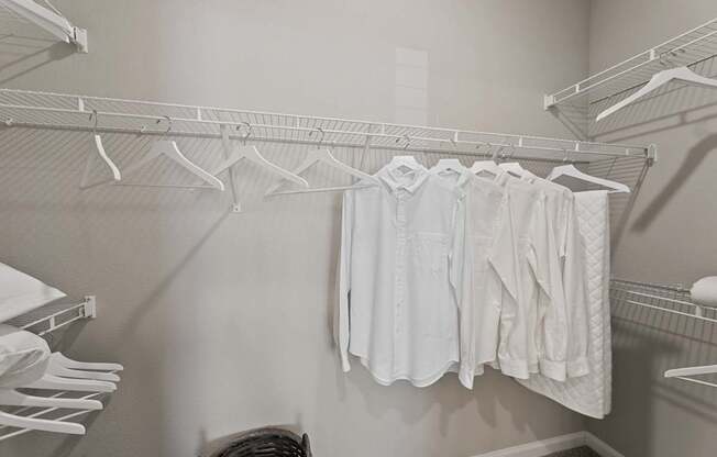 A row of white clothes hanging on a clothes rack.