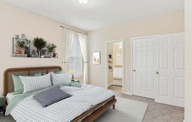 A bedroom with a bed, nightstand, and a window with curtains.