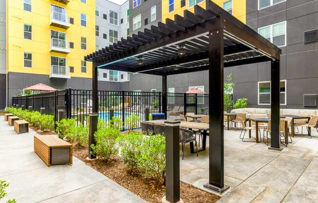 a patio with tables and chairs and a pergola