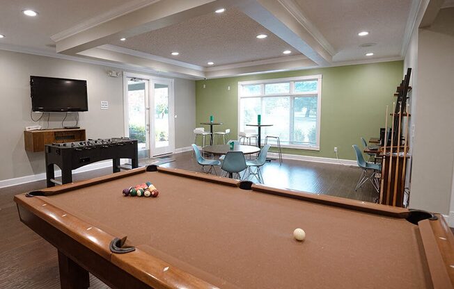 a game room with a pool table and a television