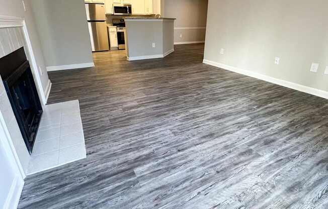 A living room with a grey floor and a television on the left side.