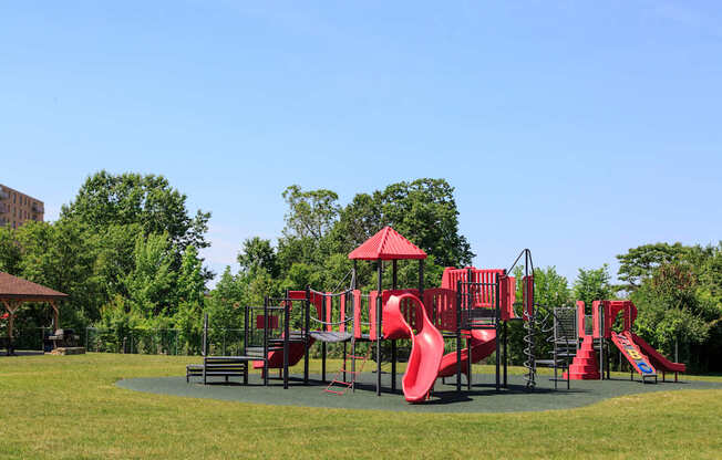 A playground with a red slide and a green lawn at Hummingbird Pointe & The Gardens, Ohio