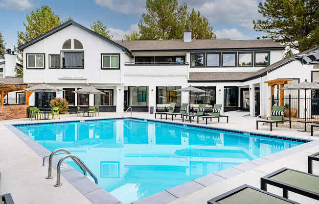 A large white house with a pool in the backyard.