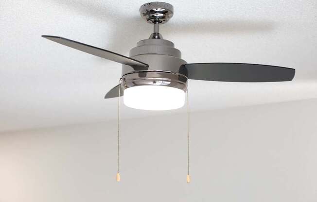 A ceiling fan with a light on.