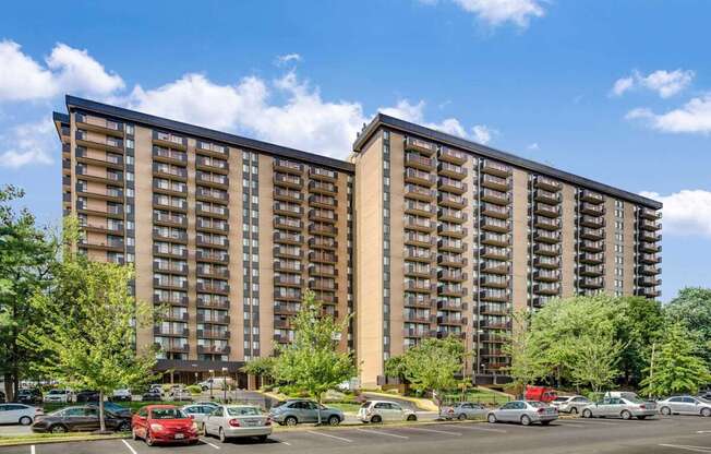 A large apartment building with a parking lot in front.