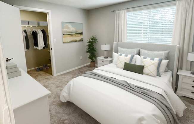 a bedroom with a large window and white furniture