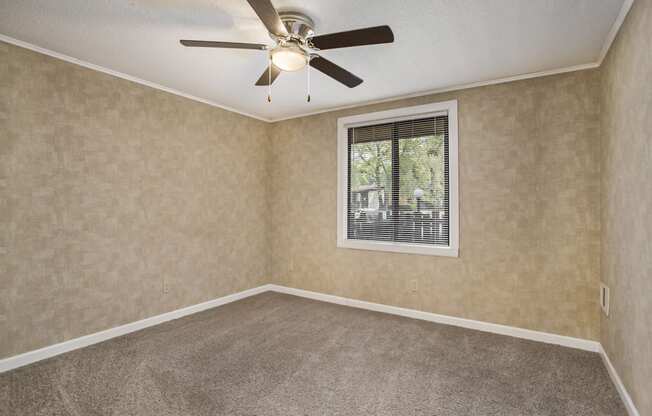 a bedroom with a ceiling fan and a window