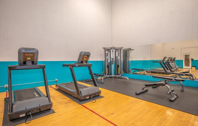 A gym with treadmills, exercise bikes, and weight machines.