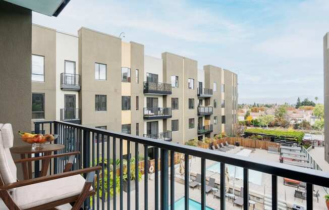 A balcony with a chair and a table with food on it.