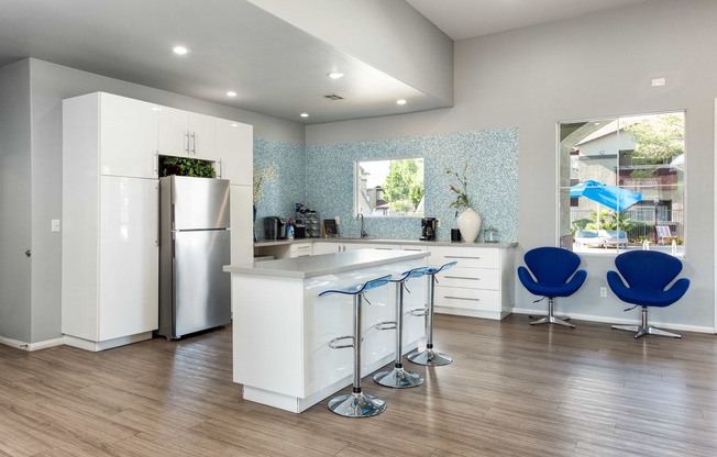 a kitchen with an island and blue chairs