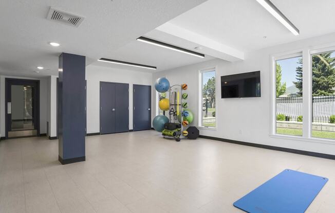 an empty room with a blue yoga mat and balloons at The Flats at Riverwoods, Provo, Utah