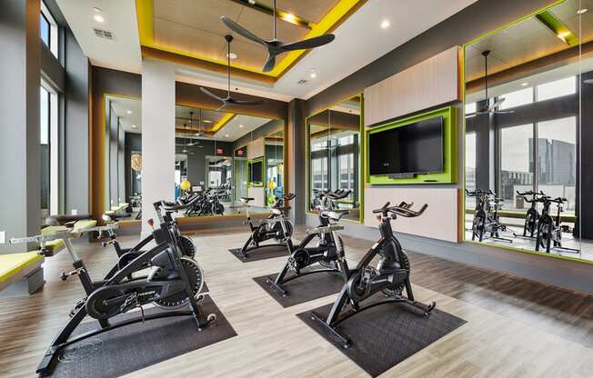A gym with exercise bikes and a television.