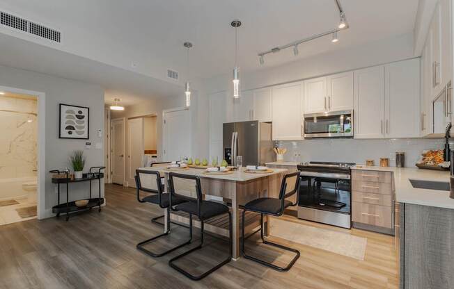A modern kitchen with a dining table and chairs.