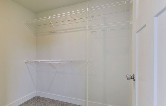 a walk in closet in a bedroom with white walls and a white doorat Chase Creek Apartment Homes, Huntsville, 35811