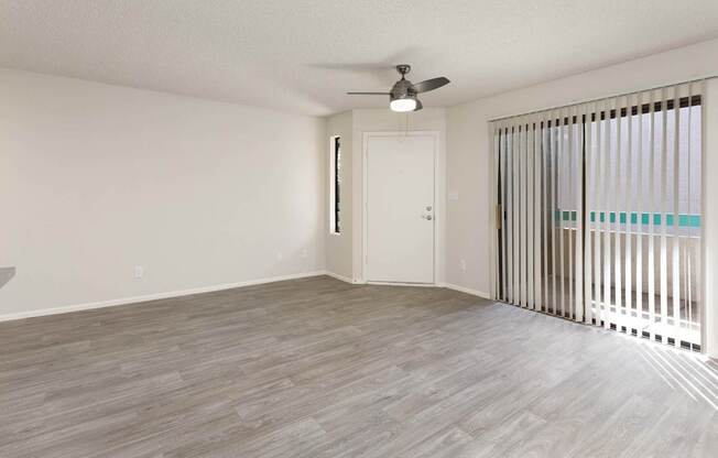 A room with a ceiling fan and a door.