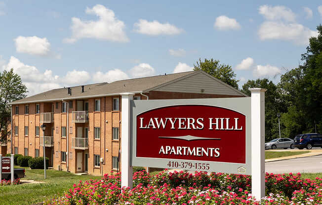 A sign for Lawyers Hill Apartments in front of a building.