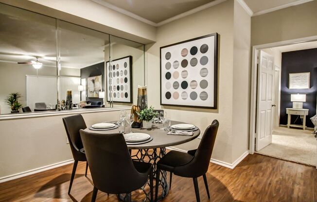 Cozy dining nook with hardwood style flooring, crown molding and wall mirror