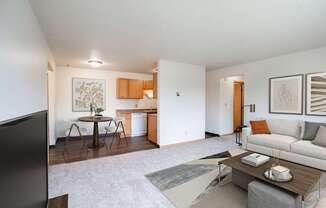 A living room with a couch, coffee table, and television. West Fargo, ND Saddlebrook Apartments