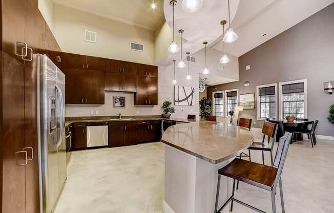 a large kitchen with a large center island with a marble countertop