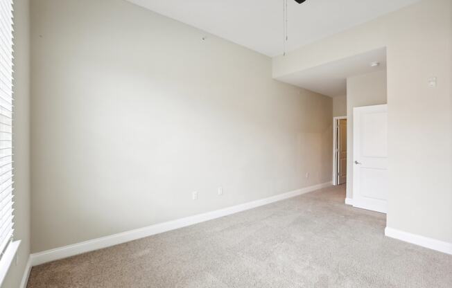 an empty living room with white walls and carpet