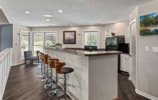 a kitchen with a bar with chairs and a counter