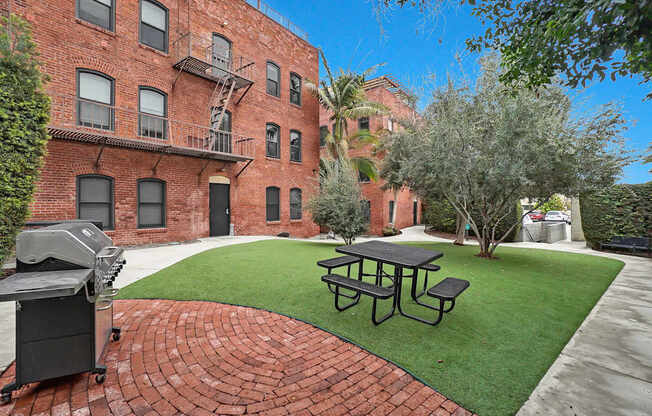 A brick building with a fire escape and a picnic table in front.