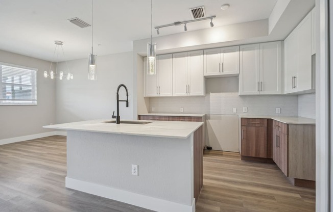 an open kitchen with a large white island and white cabinets