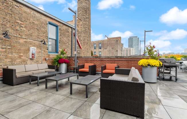 an outdoor patio with tables and chairs and a brick wall