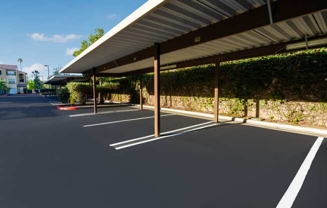 a parking lot with awning and vines on the side of a building