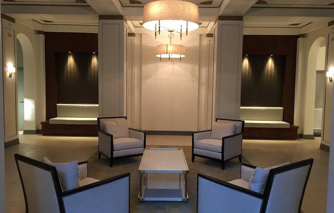 A well-lit waiting area with a couch, chairs, and a table.