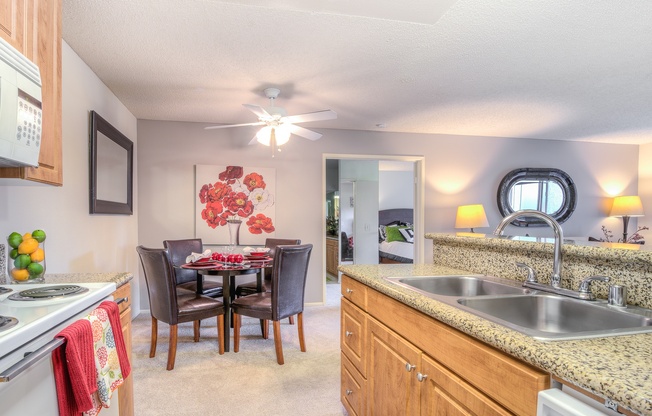A kitchen with a table and chairs in the middle.