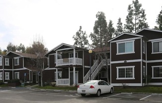 a row of houses with a car parked in a parking lot