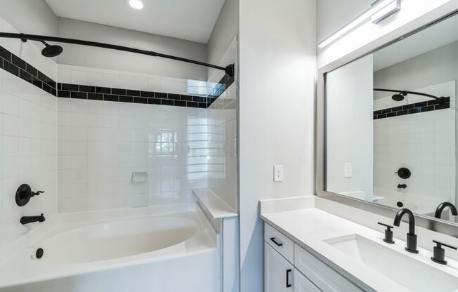 a bathroom with a tub and a sink and a mirror