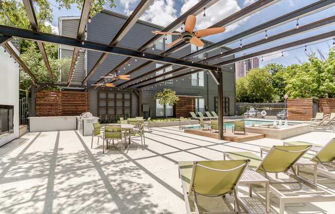 a patio with a pool and lounge chairs and a ceiling fan