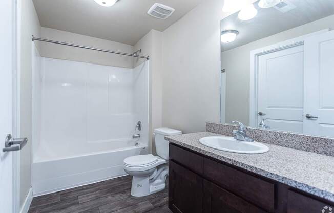 A white toilet sits in a bathroom next to a sink.