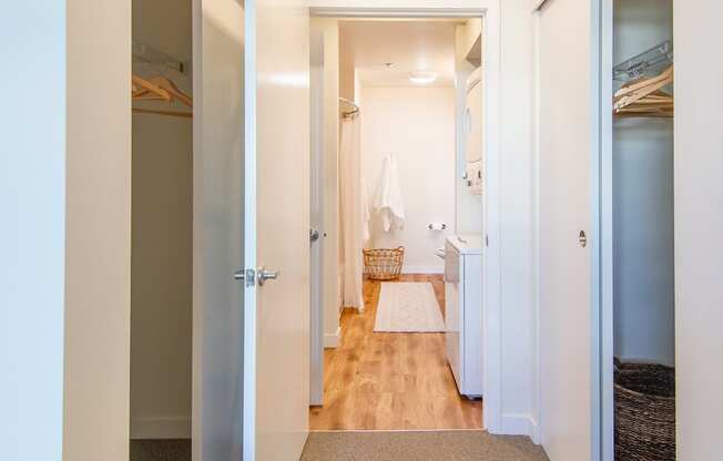 A hallway with a carpeted floor and white walls.