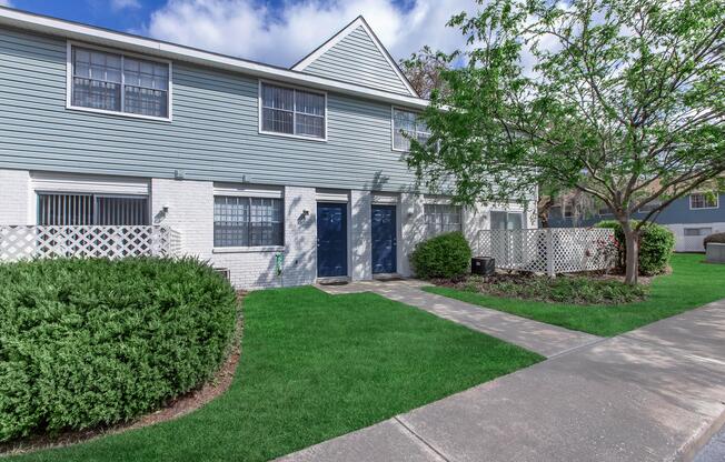 a large brick building with grass in front of a house