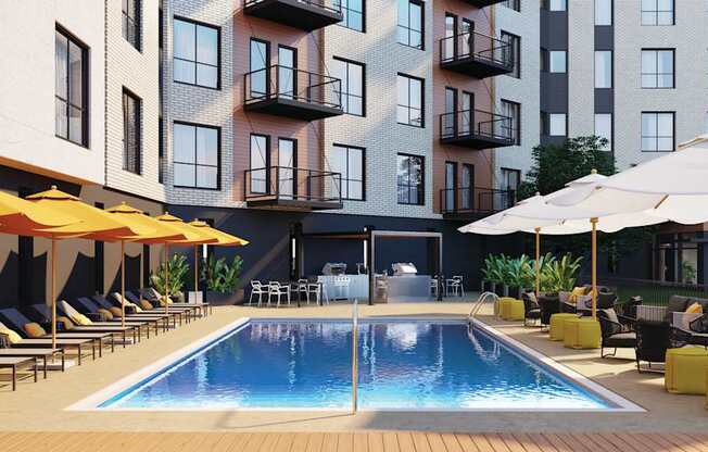 A pool surrounded by lounge chairs and umbrellas in front of a building.