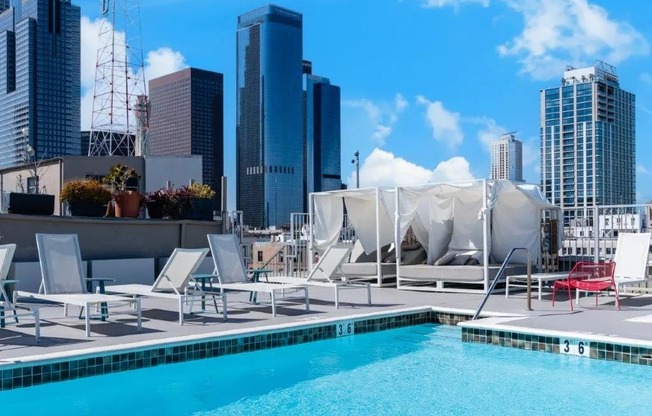 a pool on the roof of a building with skyscrapers in the background