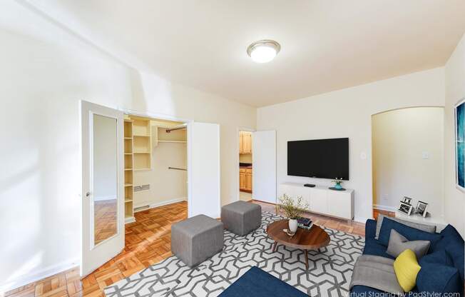 living area with hardwood flooring, social seating, coffee table and tv at baystate apartments in washington dc