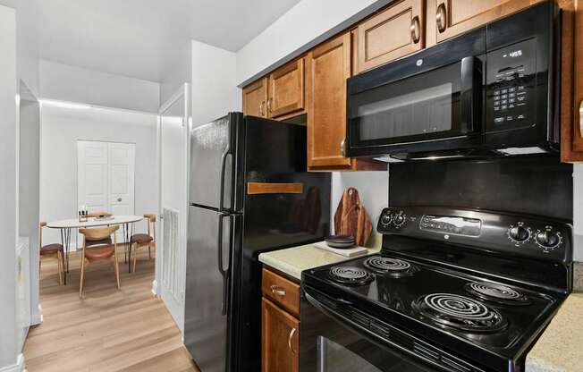 A black stove top oven sits under a microwave in a kitchen.