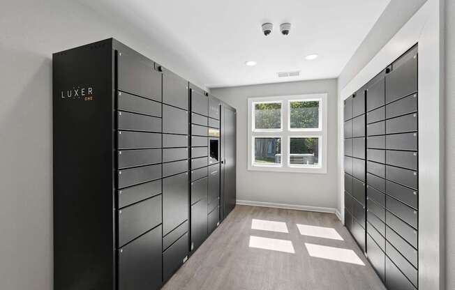 A hallway with a black wall and a window with a view of trees.