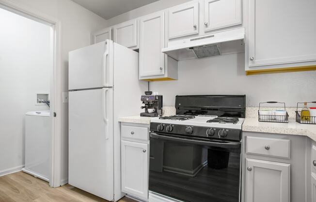 a kitchen with white cabinets and a stove and refrigerator
