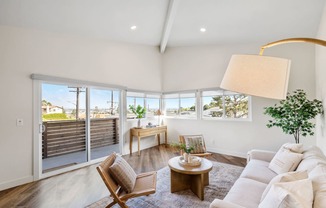 a living room with a white couch and a sliding glass door