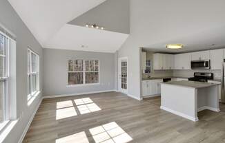 a living room with a kitchen and a large window