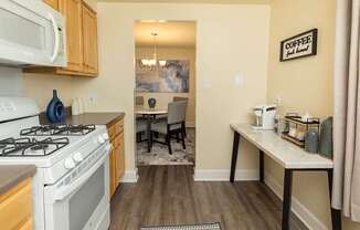 A kitchen with a white stove and a white microwave above it.
