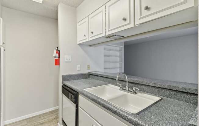 the kitchen of our A4 apartment atrium with white cabinets and a sink