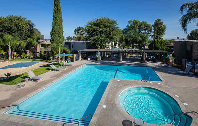 Sparkling Pool and Spa Surrounded By Lounge Seating, Umbrellas, and Greenery at Aspire Upland Apartments, Upland, 91786